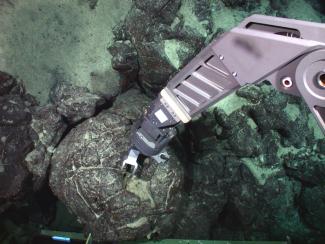 Robotic mechanical arm on the JASON2 submersible collecting a pillow lava sample from Mauna Loa volcano